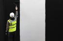 A worker paints a wall on a construction site in London