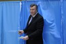 Ukrainian President Viktor Yanukovich leaves a booth for voting at a polling station during parliamentary elections in Kiev, Ukraine, Sunday, Oct. 28, 2012. (AP Photo/Sergei Chuzavkov)