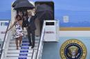 US President Barack Obama waves next to First Lady Michelle Obama as they arrive with their daughters Sasha and Malia (behind) at Jose Marti international airport in Havana on March 20, 2016