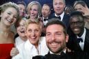 This image released by Ellen DeGeneres shows actors, front row from left, Jared Leto, Jennifer Lawrence, Meryl Streep, Ellen DeGeneres, Bradley Cooper, Peter Nyong'o Jr. and, second row, from left, Channing Tatum, Julia Roberts, Kevin Spacey, Brad Pitt, Lupita Nyong'o and Angelina Jolie as they pose for a "selfie" portrait on a cell phone during the Oscars at the Dolby Theatre on Sunday, March 2, 2014, in Los Angeles. (AP Photo/Ellen DeGeneres)