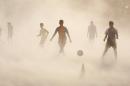10ThingstoSeeSports - Aspiring young Indian soccer players continue with their practice during a dust storm in Jammu, India, Wednesday, June 11, 2014. Soccer fans around the world are gearing up to watch the Soccer World Cup that begins in Brazil on Thursday. (AP Photo/Channi Anand, File)