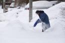 A resident clears snow following an overnight snow storm in Toronto, Ontario