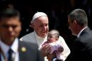 Pope Francis holds a baby after celebrating a Mass at San Cristobal de las Casas