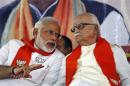 BJP leader Advani listens to BJP prime ministerial candidate Modi during a workers' party meeting at Gandhinagar