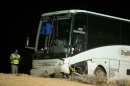 An Arizona Highway Patrol officer examines the exterior of a tour bus that careened off the highway and crashed off northbound highway 93, Friday, Oct. 19, 2012, near Willow Beach, Ariz. The crash killed the driver and left at least four passengers with serious injuries. About 45 other passengers were less seriously hurt and not all of them required hospital treatment, the Arizona Highway Patrol said. (AP Photo/Julie Jacobson)