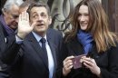 French President and UMP candidate Nicolas Sarkozy and his wife Carla Bruni-Sarkozy leave after casting their votes in the first round of French presidential elections in Paris, France, Sunday, April 22, 2012. (AP Photo/Michel Euler)