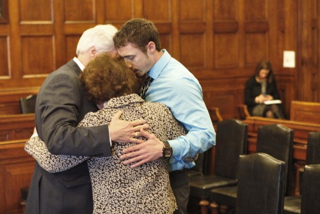 Mark Strong Sr., his wife Julie and their son Bradley hug during a recess in Cumberland County Unified Criminal Court in Portland, Maine, on Thursday, March 21, 2013. Julie Strong was overcome with emotion while addressing Justice Nancy Mills so Mills called for a recess to allow Strong to compose herself. Mark Strong was sentenced to 20 days in jail and ordered to pay $3,000 in fines. In the background at right is Sarah Churchill, attorney for Alexis Wright. (AP Photo/Portland Press Herald, Gregory Rec, Pool)