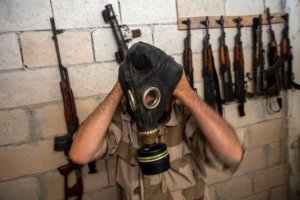 A Syrian rebel tries on a gas mask seized from an arms …
