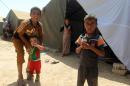 Iraqi children -- who fled with their families the city of Ramadi after it was seized by Islamic State (IS) militants -- gather outside tents at a camp housing displaced families in Bzeibez, on May 18, 2015