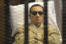 Former Egyptian President Mubarak sits inside a cage in a courtroom in Cairo