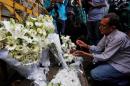 A man lights a candle at a makeshift memorial, to pay tribute to the victims of the attack on the Holey Artisan Bakery and the O'Kitchen Restaurant, near the site of the attack in Dhaka