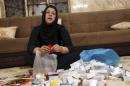 Hamida Hassan Mohammed one of victims of the 1988 chemical attack on Halabja, empties a bag of medicine in her home in Halabja