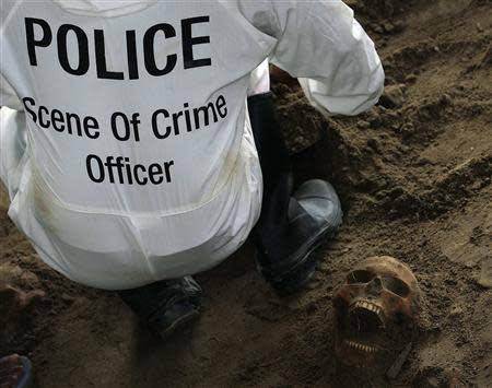 A police officer works next to a human skull at a construction site in the former war zone in Mannar
