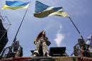 A woman sits on an armoured personnel vehicle during a rally at Independence Square in Kiev