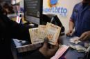 A customer shows their tickets for the Powerball lottery at the CA lotto store in San Bernardino County, California