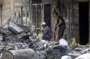 Free Syrian Army fighters take up position along a street filled with debris in Sheikh Maksoud area in Aleppo