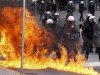 A petrol bomb explodes near riot police during protests against planned reforms by Greece's coalition government in Athens