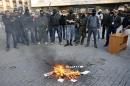 Masked pro-Russia protesters burn campaign material of Yulia Tymoshenko outside a regional government building in Donetsk