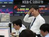 A currency trader reacts in front of screens showing the Korea Composite Stock Price Index (KOSPI), center, and foreign exchange rate, right, at the foreign exchange dealing room of the Korea Exchange Bank headquarters in Seoul, South Korea, Thursday, Nov. 8, 2012. South Korea's Kospi dropped 1.19 percent at 1,914.43. (AP Photo/Ahn Young-joon)