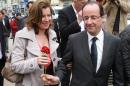 FILE - In this May 5, 2012 file photo, French Socialist Party candidate for the presidential election Francois Hollande, right, offers a rose to his companion Valerie Trierweiler, in Tulle, southwestern France. The woman considered France's first lady was hospitalized after a report the president is having an affair with an actress, her office said Sunday, as a poll was released showing the French shrugging off any liaison as none of their business. (AP Photo/Bob Edme, File)