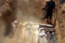 An image grab from a video uploaded on YouTube by the Local Committee of Arbeen on August 21, 2013 allegedly shows Syrians covering a mass grave containing bodies of victims of a toxic gas attack on the outskirts of Damascus