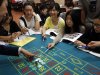 In this Nov. 25, 2012 photo, a gambling school students practice on a table in Macau, China. The students sitting around the roulette table are getting schooled on how to quickly calculate payoffs for the casino game by glancing at how the bets are placed. Elsewhere in the room, the biggest mock casino in Asia, other students are playing practice hands of blackjack or learning how to run a craps table. (AP Photo/Vincent Yu)