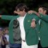 Charl Schwartzel, right, of South Africa, helps Bubba Watson put on the green jacket after winning the Masters golf tournament following a sudden death playoff on the 10th hole Sunday, April 8, 2012, in Augusta, Ga. (AP Photo/David J. Phillip)