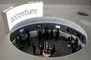 Visitors look at devices at Accenture stand at the Mobile World Congress in Barcelona