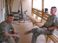This 2007 photo provided by Brock McNabb shows Pete Linnerooth, right, and Travis Landchild sitting outside their mental health clinic in Baghdad. McNabb, Landchild and Linnerooth were the tight-knit mental health crew in charge of the 2nd Brigade Combat Team, 1st Infantry Division in the Baghdad area. They were there when the surge began, rocket attacks increased and the death toll mounted. Fairchild says the three dubbed themselves "a dysfunctional tripod." Translation: One of the three 'legs' was always broken, or stressed out, and without fail, "the other two would step up and support that person." (AP Photo/Brock McNabb)