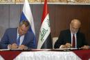 Iraqi Foreign Minister Ibrahim al-Jaafari (R) and Russia's Deputy Prime Minister Dmitry Rogozin (L) sign documents in Baghdad