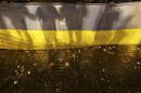 Participants of an anti-war rally hold a national flag as eggs thrown by pro-Russia protesters cover the floor during their clashes in Donetsk