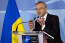 Ukraine's Ambassador to NATO Ihor Dolhov adjusts the microphones prior to speaking during a media conference at NATO headquarters in Brussels on Sunday, March 2, 2014. NATO is called emergency talks on Sunday regarding the escalating crisis in Ukraine. (AP Photo/Virginia Mayo)