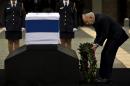 Israel's President Shimon Peres lays a wreath next the coffin of late Israeli Prime Minister Ariel Sharon at the Knesset Plaza, Israeli Parliament, in Jerusalem, Sunday, Jan. 12, 2014. Sharon, the hard-charging Israeli general and prime minister who was admired and hated for his battlefield exploits and ambitions to reshape the Middle East, died Saturday, eight years after a stroke left him in a coma from which he never awoke. He was 85. (AP Photo/Bernat Armangue)