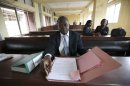 Leonard Dibia, a lawyer representing victims of crash look through court documents during a ruling at the Magistrate court in Lagos, Nigeria, Wednesday, April. 25, 2012,The failures of Africa's most populous nation seemed to explode into a fiery multiple car and truck crash in Nigeria that killed at least 18 people in 2010, according to a coroner's ruling issued Wednesday. Police set up an illegal checkpoint August 2010 along a major expressway in Lagos, using tires to funnel traffic down to one lane as officers demanded bribes from motorists, witnesses said. The driver of a speeding truck carrying sugar for the nation's largest industrial company tried to stop, but the vehicle's bad brakes failed and the truck slammed into waiting traffic, witnesses and officials said. Those details, long denied by authorities, came out Wednesday when a coroner investigating the deaths ruled against Nigeria's federal police and the Dangote Group, owned by billionaire Aliko Dangote. (AP Photos/Sunday Alamba)