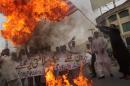 A Pakistani demonstrator holds a burning US flag during a protest in Multan on May 24, 2016, against a US drone strike in Pakistan's southwestern province Balochistan