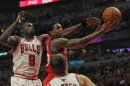 Louis Williams of the Philadelphia 76ers goes up for a shot between Loul Deng (L) and Kyle Korver of the Chicago Bulls