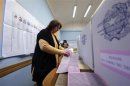 Voting officials prepare ballot papers in a polling station in Rome