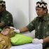 In this photo taken on Aug. 20, 2011, Suratmi, left, receives a treatment at Insani Herbal Clinic in Depok on the outskirts of Jakarta, Indonesia. The 47-year-old housewife, who suffers from an ovarian cyst, has been taking a mix of herbal medicine harking back to the dawn of Islam, as well as undergoing exorcisms. She is among a growing number of Muslims in Southeast Asia turning away from Western medical care in favor of al-Tibb al-Nawabi, or Medicine of the Prophet, a loosely defined discipline based on the Quran and other Islamic texts and traditional herbal remedies. (AP Photo/Irwin Ferdiansyah)