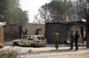 Nigerian soldiers inspect a burnt vehicle at the site of a suicide attack by the Boko Haram militant group in Maiduguri, northeast Nigeria on January 30, 2016
