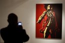 Visitor photographs a painting of South Africa's President Jacob Zuma at an exhibition in Johannesburg