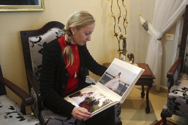 In this Wednesday, Feb. 20, 2013 photo, Ukrainian Alla Evdokimova, 26, who now goes by name Alaa Altif, displays her wedding album at her home at Mount Gerizim, near the West Bank town of Nablus. Alia emigrated to the West Bank and married Samaritan, Azzam Altif. The Samaritans, a rapidly dwindling sect dating to biblical times, have opened their insular community to brides imported from eastern Europe in a desperate quest to preserve their ancient culture. (AP Photo/Nasser Ishtayeh)