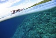 Um barco circula sobre o recife de corais do parque nacional marinho de Manado, na Indonésia