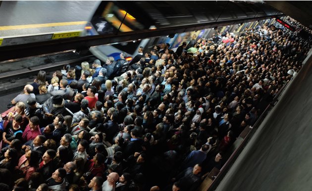 Commuters wait for the train at a subway station in downtown Sao Paulo