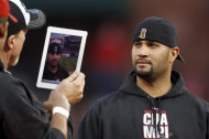 El coach Mark McGwire,a la izquierda, le saca una foto a Albert Pujols con un iPad durante una celebración del campeonato de la Serie Mundial, el domingo 30 de octubre de 2011 en San Luis. (AP Foto/Jeff Roberson)