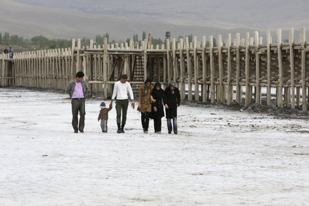 ADVANCE TO GO WITH THE STORY SLUGGED:IRAN ENVIRONMENT DISASTER, BY NASER KARIMI  An Iranian family walk on the solidified salts of the Oroumieh Lake, as they sightsee the lake, while an abandoned jett