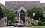 FILE - In this June 5, 2002 file photo, a van is seen outside the gate at the home of Grammy-winning singer R. Kelly in Olympia Fields, Ill. Kelly faces a $2.9 million foreclosure on his suburban Chicago mansion. Chicago Real Estate Daily reports Tuesday, July 12, 2011, that JPMorgan Chase Bank filed the foreclosure lawsuit last month in Cook County Circuit Court. The complaint states that Kelly hasn’t made monthly mortgage payments since June of last year. (AP Photo/Frank Polich, File)