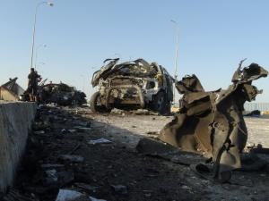 Iraqi security forces inspect the wreckage of cars …