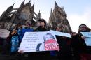 A woman holds a sign reading "Sexual harassment against women will not be tolerated" during a demonstration in front of the cathedral in Cologne on January 9, 2015