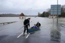 People use a boat on a flooded road near Egham, west of London on February 12, 2014