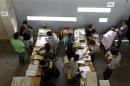People vote during the presidential election, inside a voting station at the National Stadium in Santiago